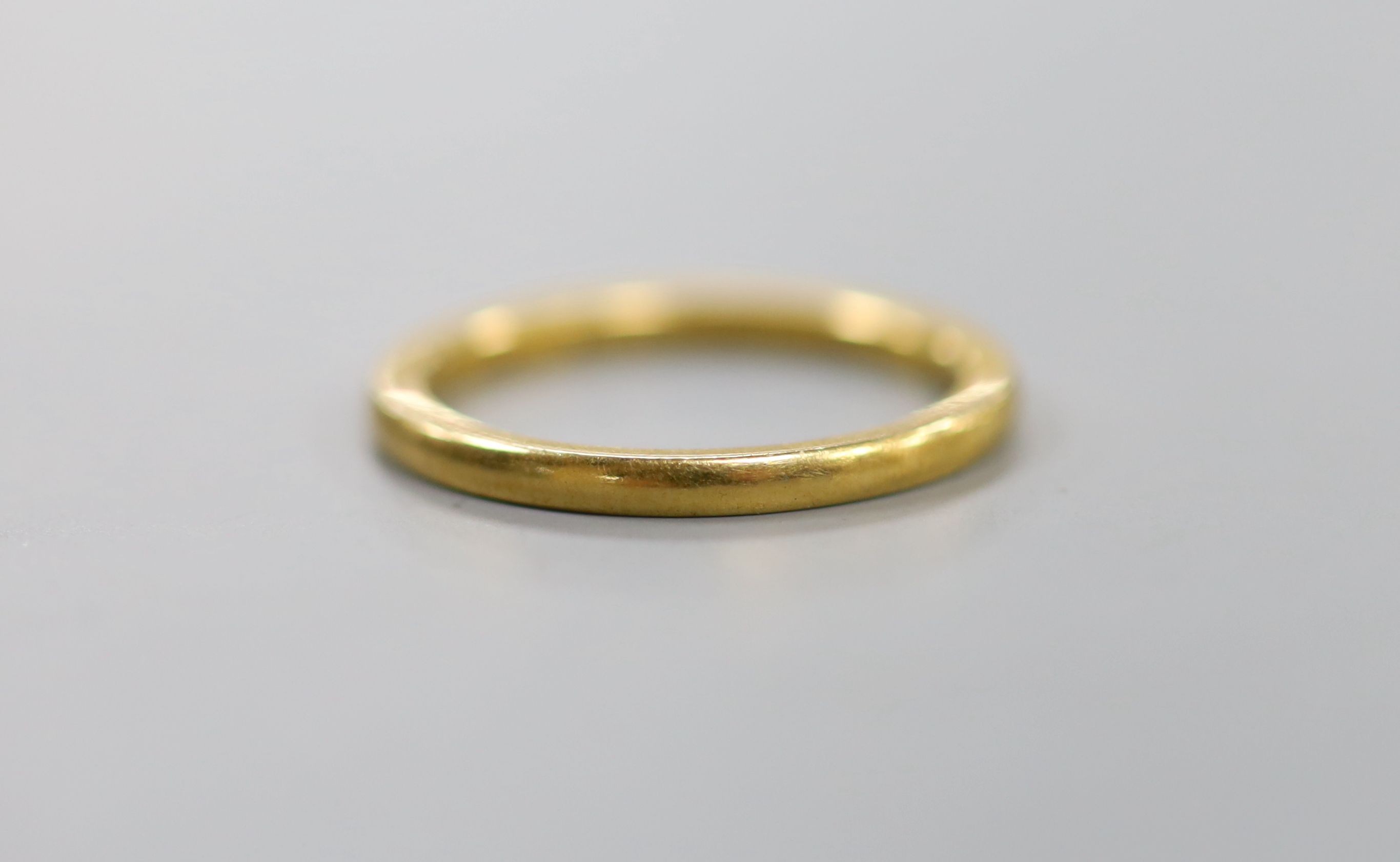 A 22ct gold wedding band, with indistinct latin? inscription to the shank, size M/N, 3.5 grams.